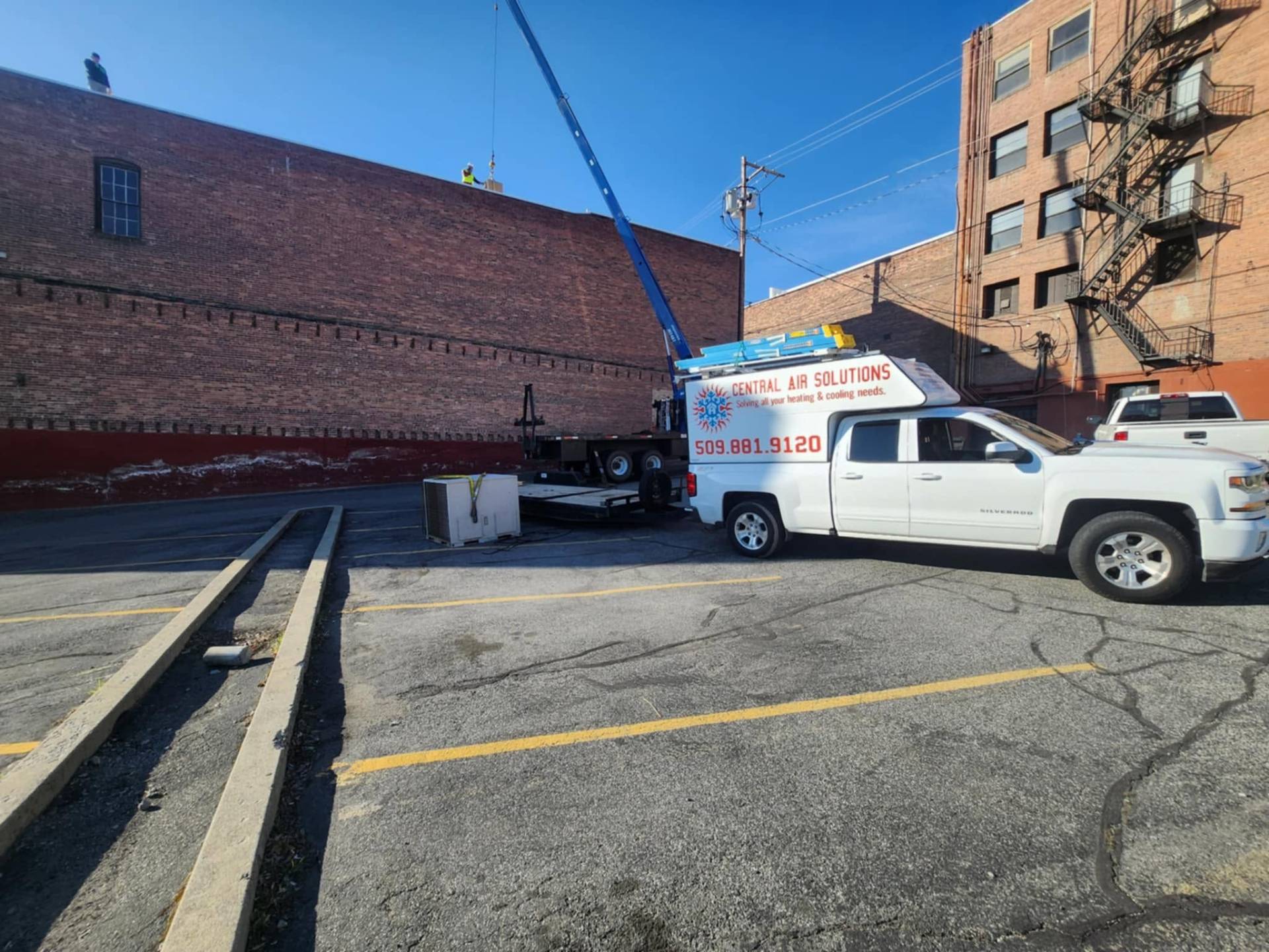 Commercial rooftop unit being craned into place downtown