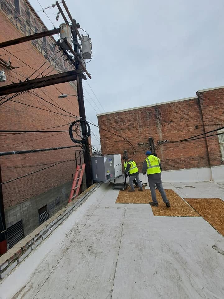 Setting the new heat pump on the rooftop pads